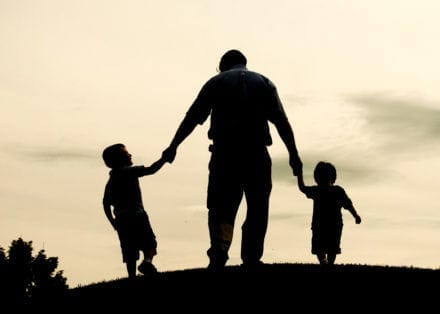Father on a hill with 2 children