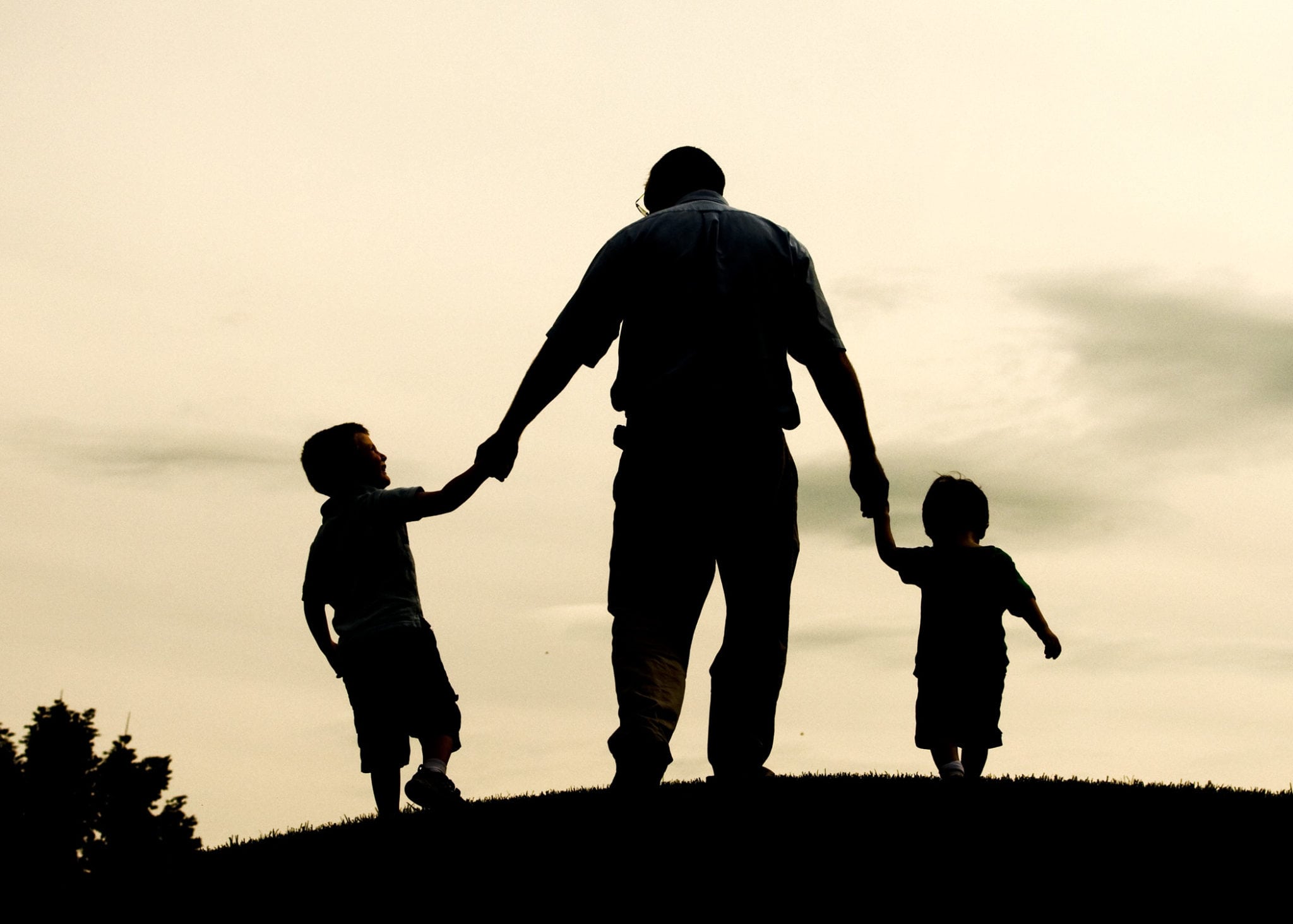 Father on a hill with 2 children