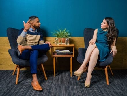 men and woman having a discussion sitting in chairs