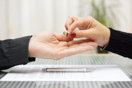 woman handing wedding to a man divorce contract and pen